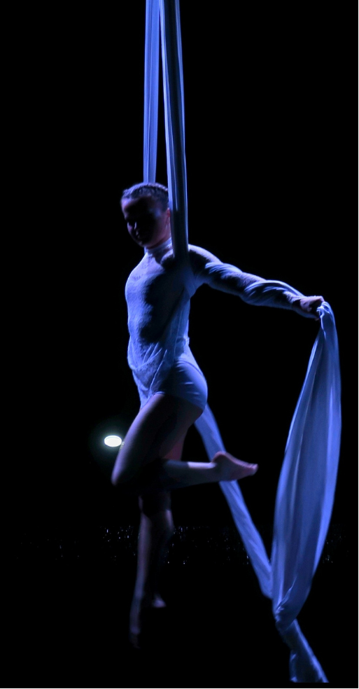 Performance sur tissu aérien sous une lumière bleue