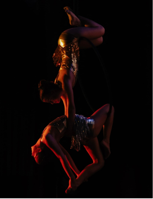 Duo acrobatique aérien sous une lumière orange